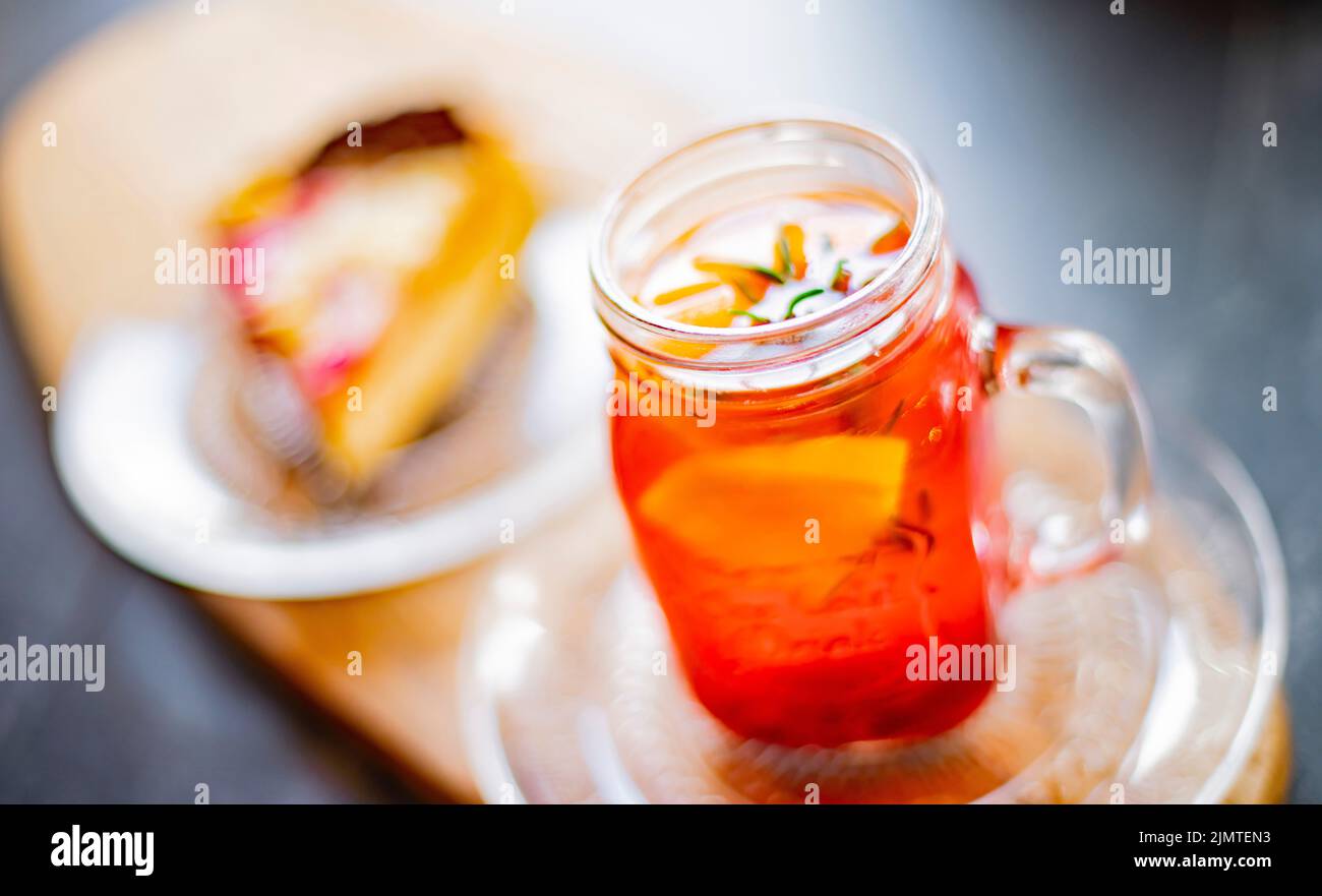 Cheesecake e un bicchiere con bevanda calda a base di frutta Foto Stock