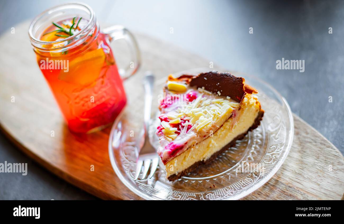Cheesecake e un bicchiere con bevanda calda a base di frutta Foto Stock
