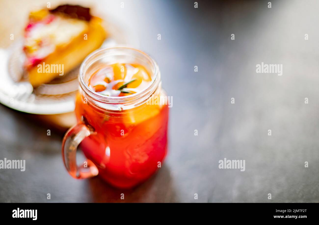 Cheesecake e un bicchiere con bevanda calda a base di frutta Foto Stock