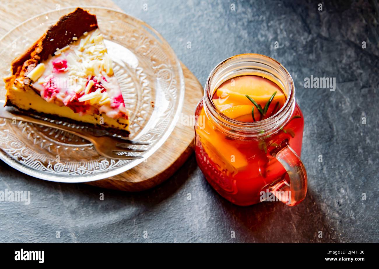 Cheesecake e un bicchiere con bevanda calda a base di frutta Foto Stock