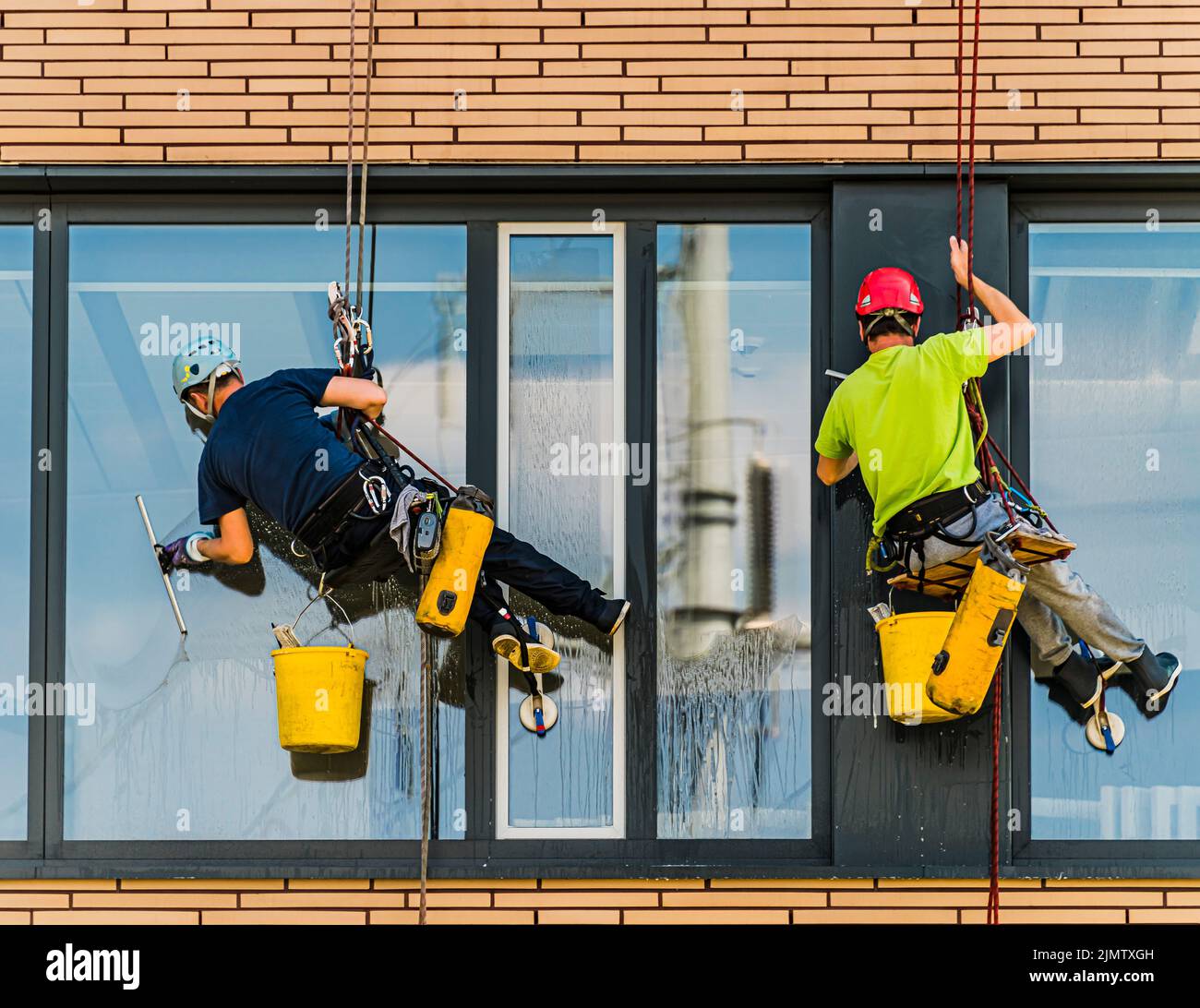 Due uomini che puliscono le finestre in un edificio di ufficio Foto Stock