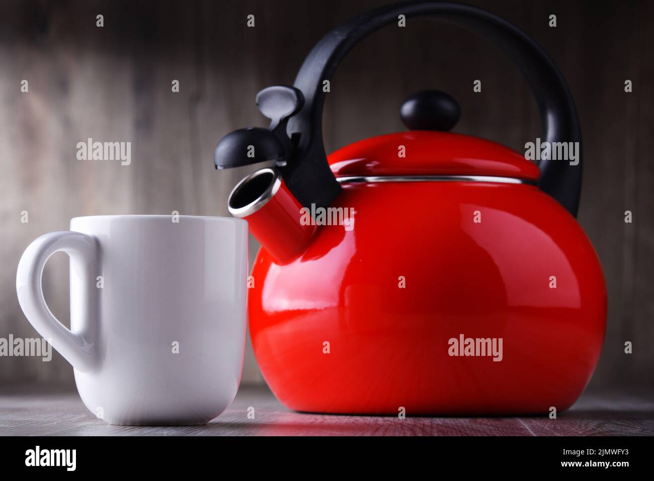 Tazza di caffè e bollitore con piano cottura in acciaio inox con fischio. Foto Stock