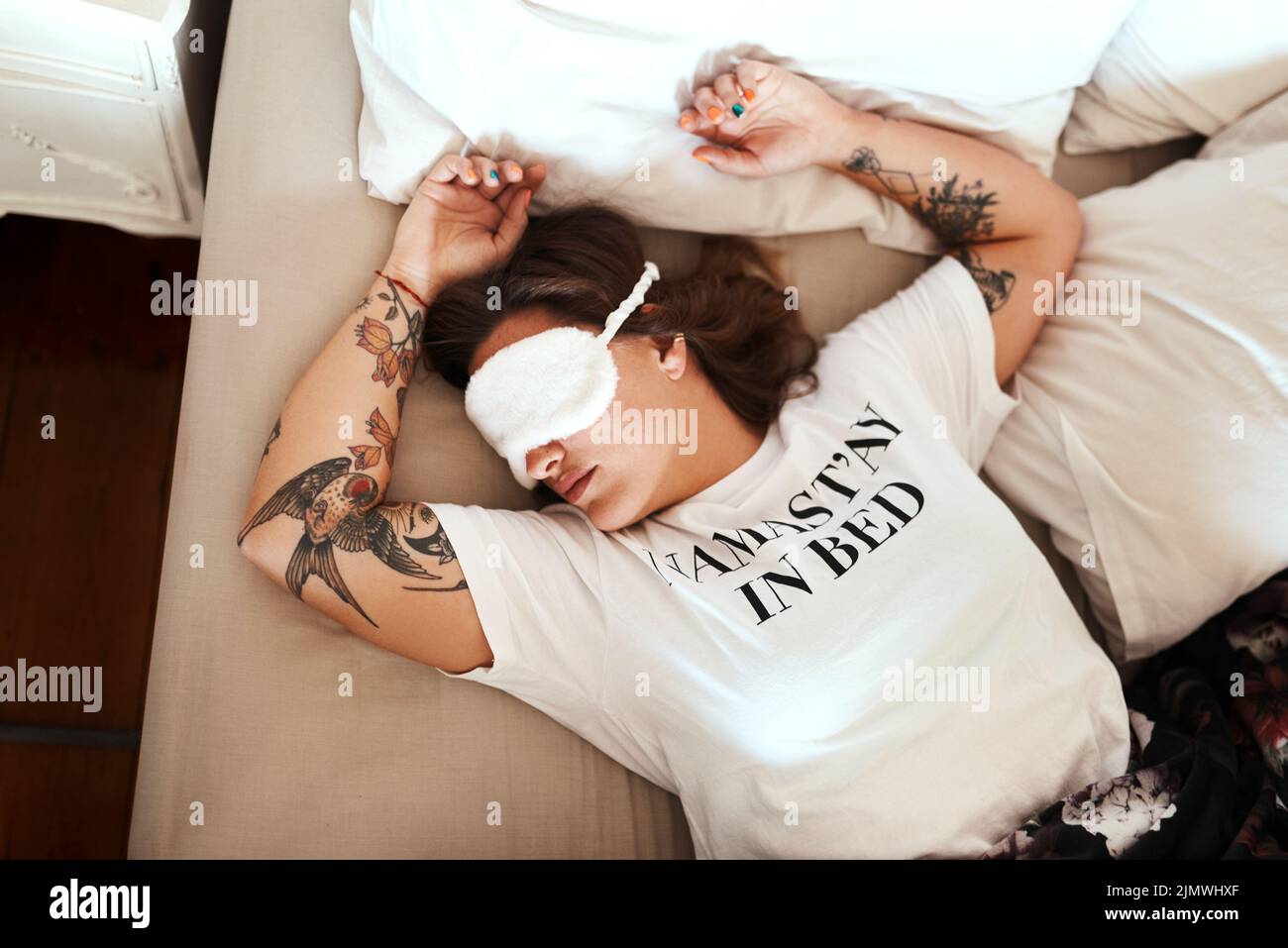 Niente e nessuno interromperà il mio sonno: Una giovane donna che indossa una maschera mentre dorme nel letto di casa. Foto Stock