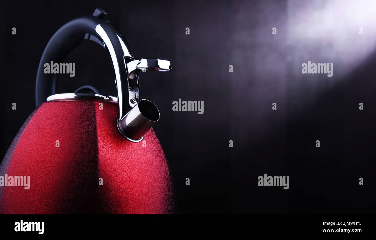 Composizione con bollitore in acciaio inox rosso con fischio Foto Stock