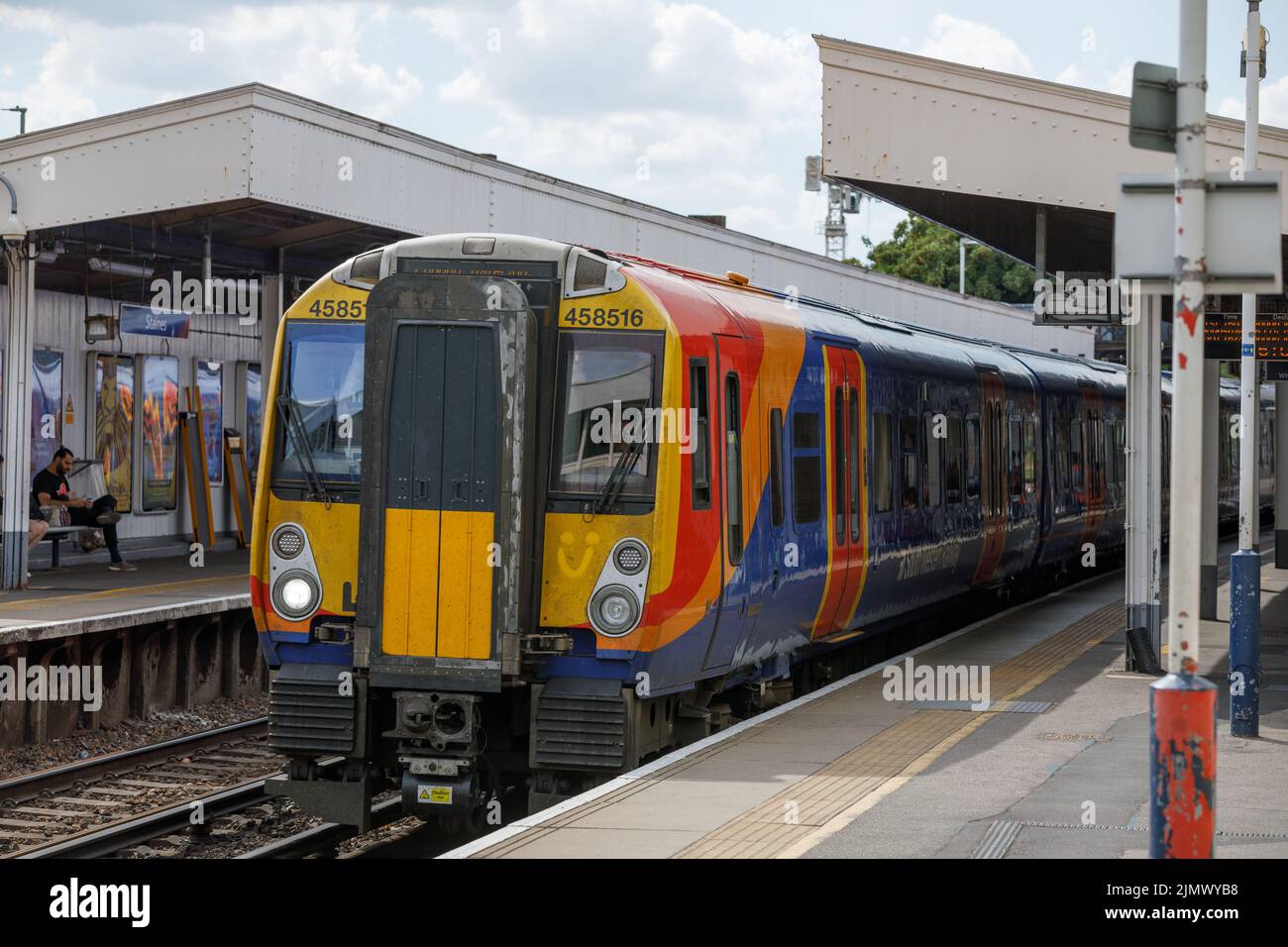 Un treno della ferrovia sud-occidentale diretto a London Waterloo attende alla stazione ferroviaria di Staines per i passeggeri di imbarcarsi e sbarcare Foto Stock