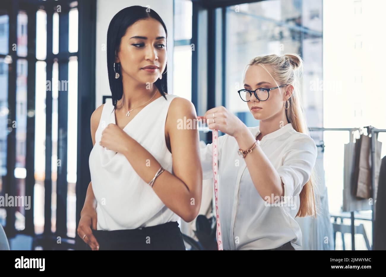 Il mio lavoro è quello di trasformare ogni sogno femminile in realtà. Un fashion designer che prende le misure dei suoi clienti nella sua officina. Foto Stock