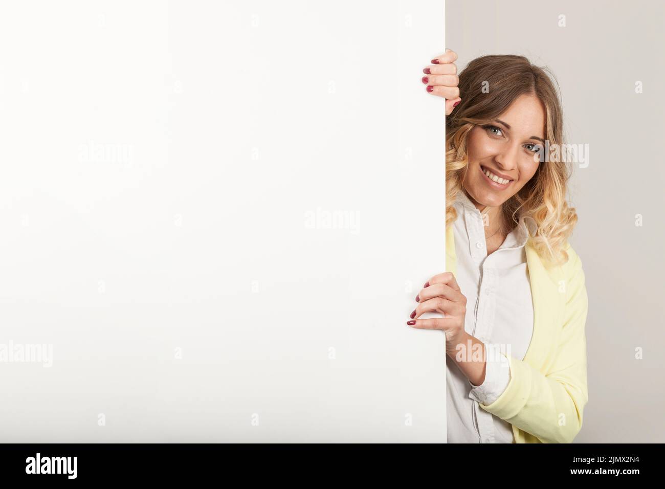 Donna che guarda oltre la porta Foto Stock