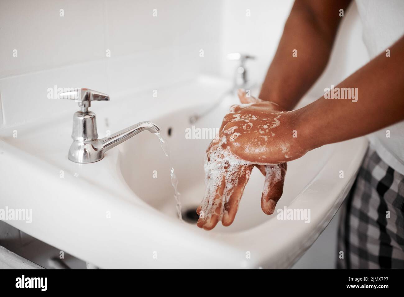 Iniziate sempre con le mani pulite, un uomo irriconoscibile che lava le mani nel bagno di casa. Foto Stock