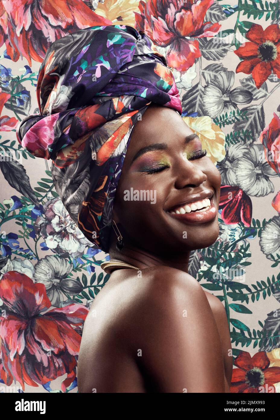 Quel bagliore che viene dalla tua anima. Studio girato di una bella giovane donna che indossa un tradizionale capo africano avvolge su uno sfondo floreale. Foto Stock