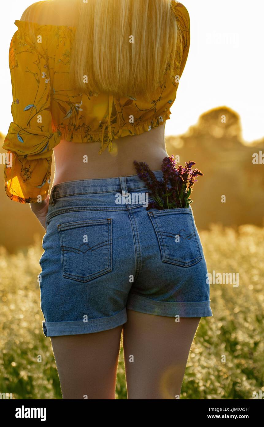 Modello femminile con fiori in tasca Foto Stock