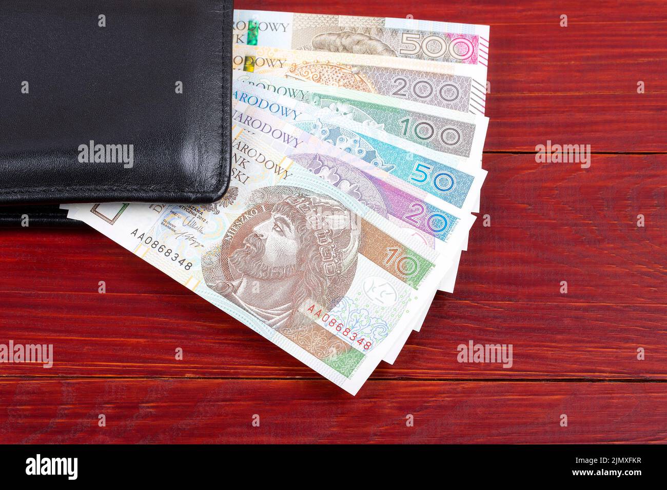 Lucidare i soldi nel portafoglio nero Foto Stock