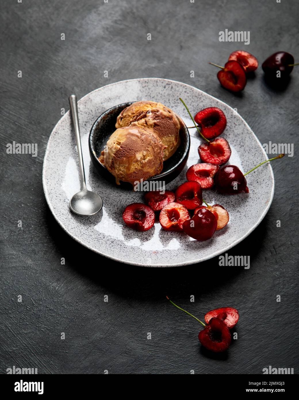 Gelato al cioccolato con frutti di bosco su sfondo scuro. Foto Stock