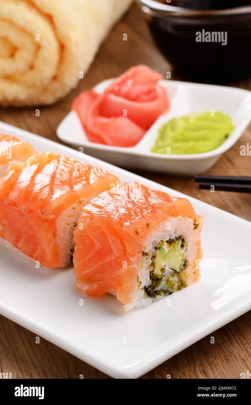 Philadelphia Roll sushi su una piastra bianca con salsa di soia wasabi e zenzero Foto Stock