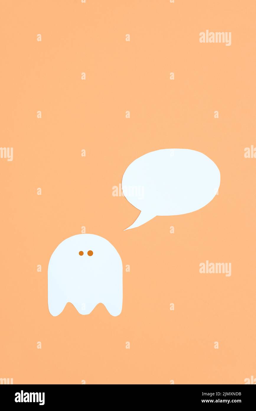 Design minimalista alla moda di Halloween, fantasma bianco carino con una bolla vuoto su sfondo arancione color pastello, composizione con spazio per la copia. Foto Stock