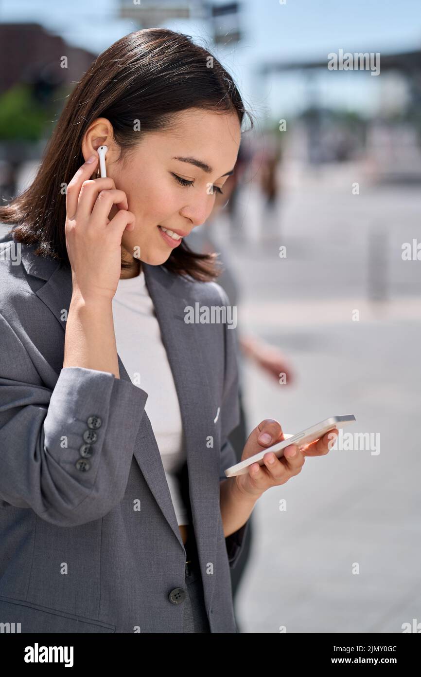 Giovane donna asiatica d'affari usando il telefono che ha video chiacchierata sulla strada della città. Foto Stock