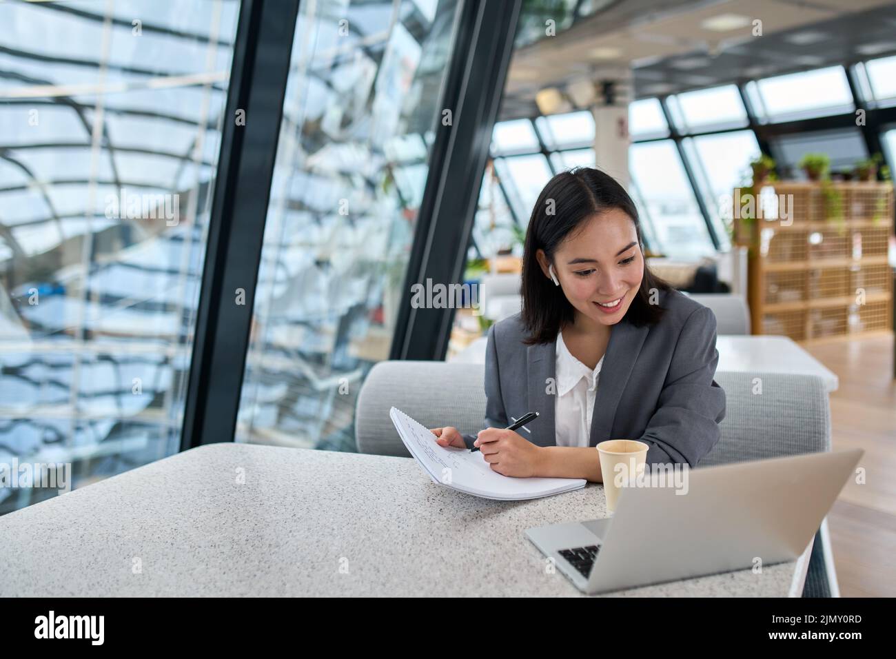 Giovane donna d'affari asiatica che utilizza videoconferenze con notebook in ufficio. Foto Stock