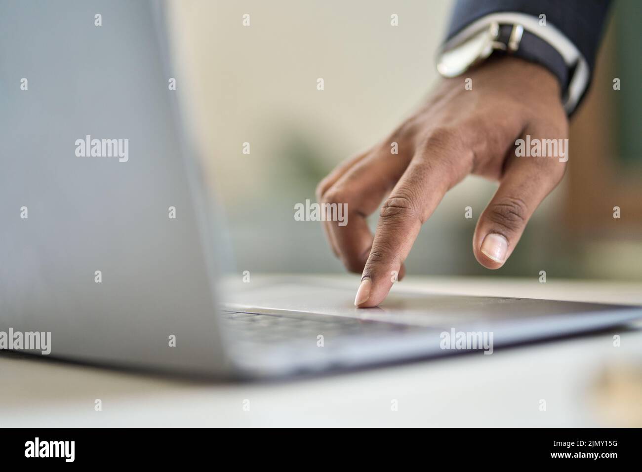 Uomo d'affari che indossa un vestito digitando un dito utilizzando un computer portatile. Primo piano Foto Stock