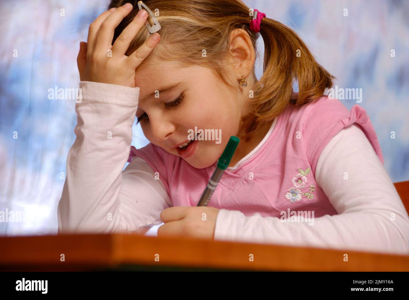 piccola ragazza che scrive su un taccuino, di nuovo al concetto della scuola Foto Stock