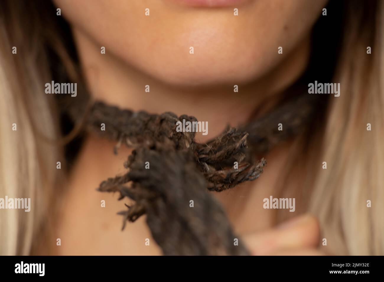 ragazza con una corda intorno al collo, traffico di esseri umani, schiavitù, potere sulle persone, una corda intorno al collo di una persona Foto Stock