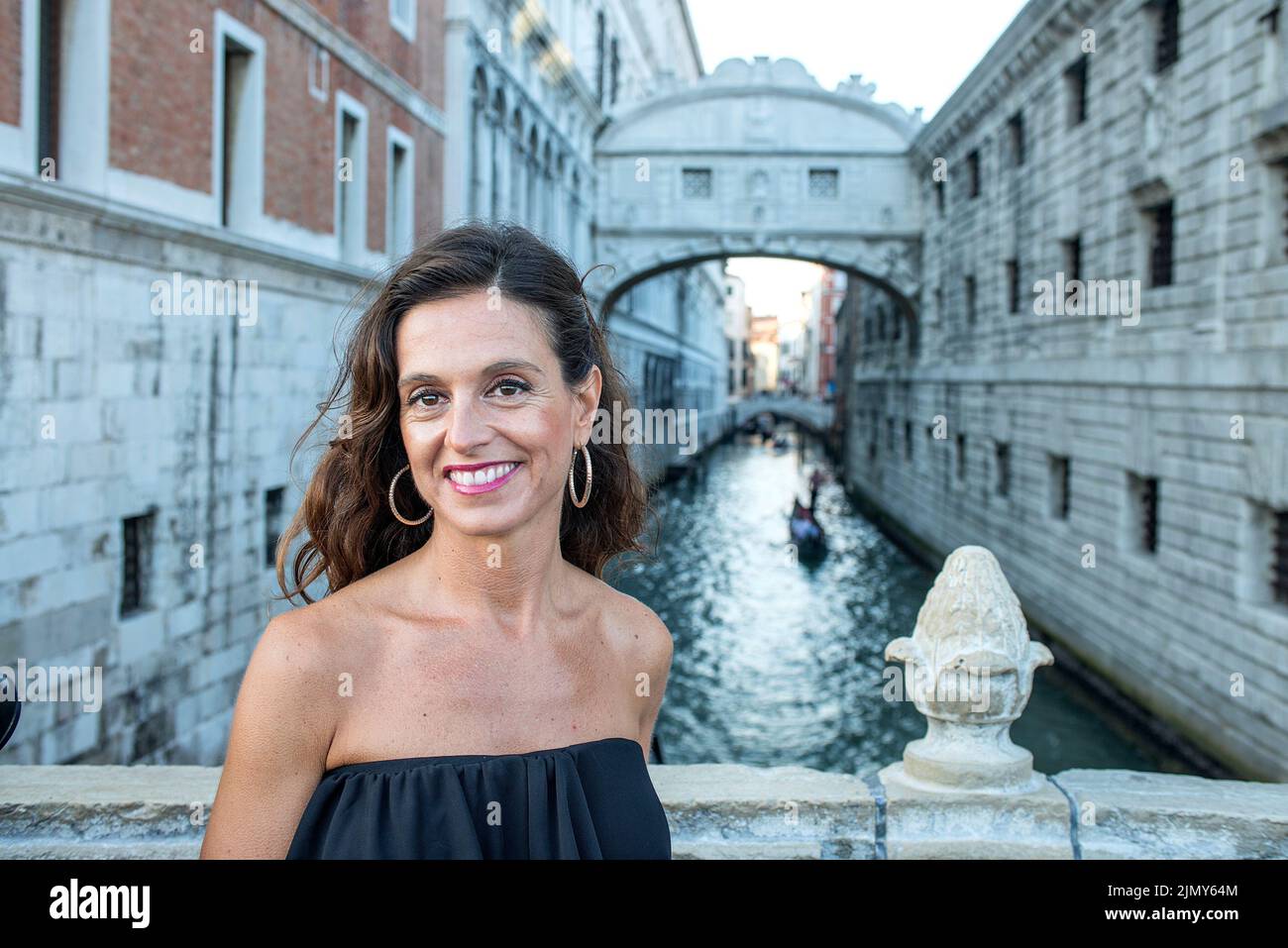 Donna latina sorridente di fronte a Bridge os Sosphs, Venezia, Italia Foto Stock