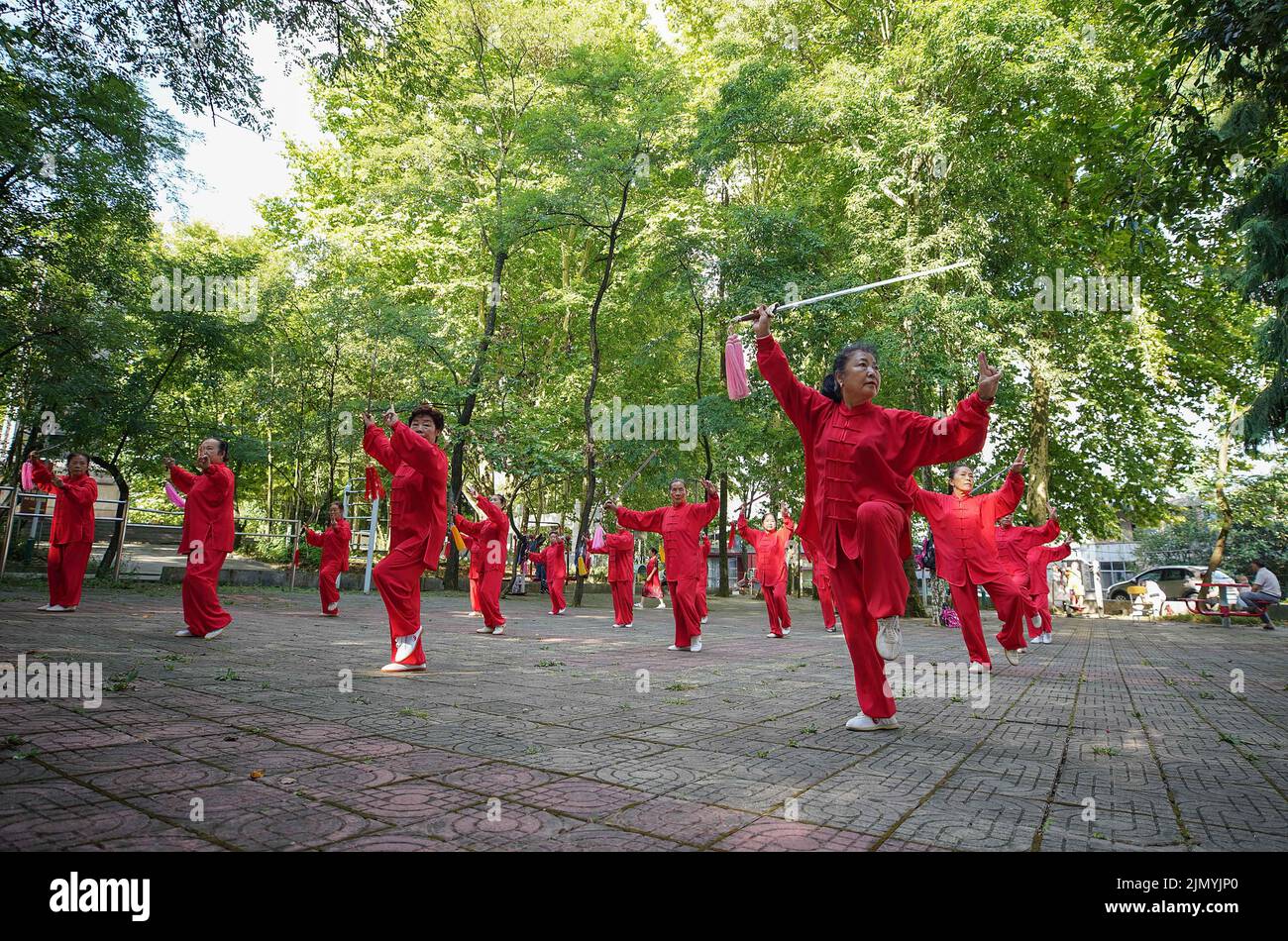 QIANDONGNAN, CINA - 8 AGOSTO 2022 - gli appassionati di fitness praticano Tai Chi Sword in un parco nella contea di Danzhai, Qiandongnan Miao e Dong pre autonomi Foto Stock