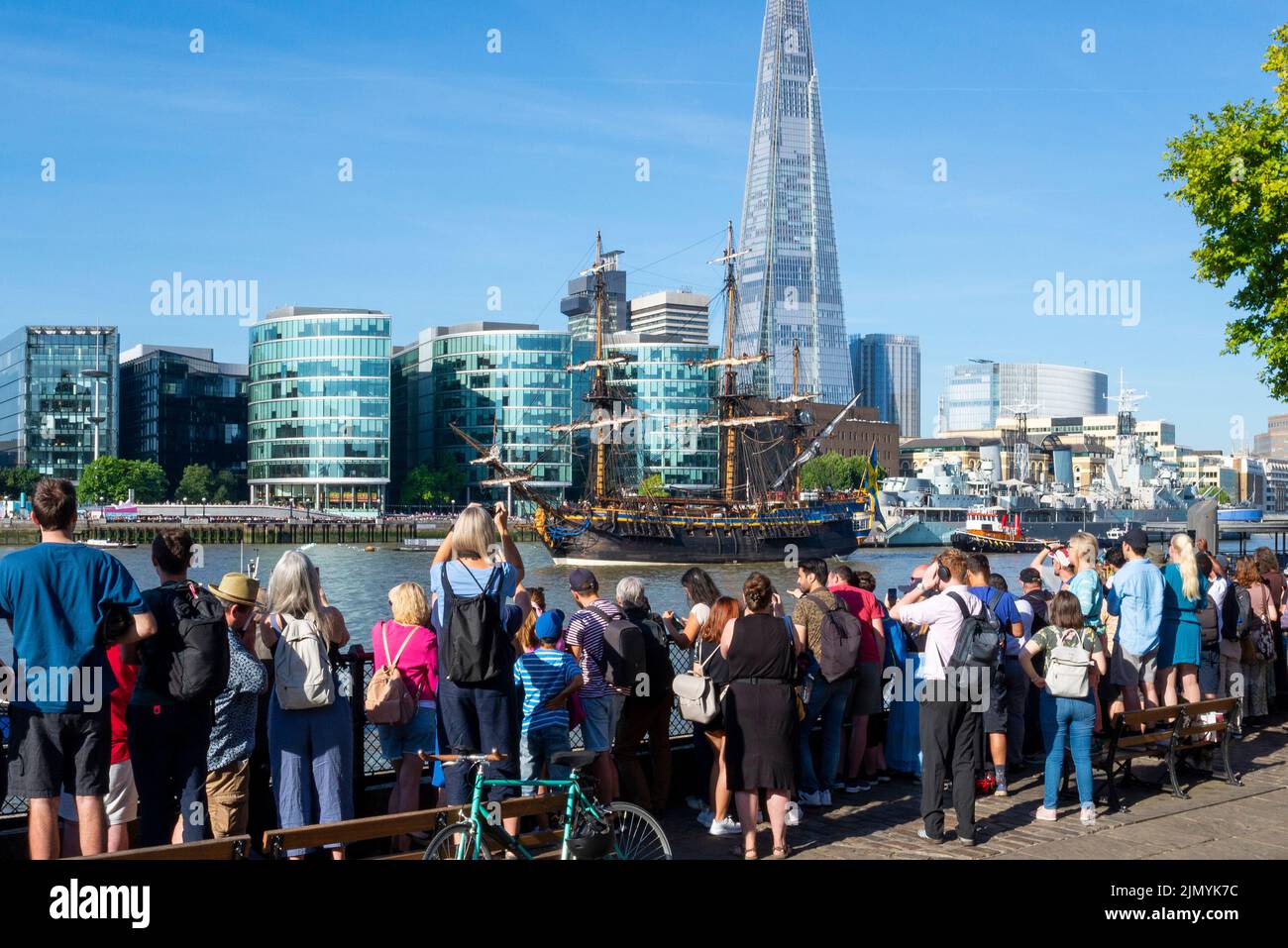 Tower Bridge, Londra, Regno Unito. 8th ago, 2022. Goteborg di Svezia è una replica a vela della svedese East Indiaman Goteborg i, lanciata nel 1738, e sta visitando Londra per accogliere i visitatori a bordo. La replica di legno fu lanciata nel 2003 e visitò Londra l'ultima volta nel 2007. Ha navigato sul Fiume Tamigi in mattinata per passare sotto il Tower Bridge aperto prima di svoltare e passare di nuovo sotto e dirigersi verso il Thames Quay a Canary Wharf, dove sarà aperto ai visitatori. Persone che guardano dalla zona di Tower Wharf, con lo Shard e molto altro Londra Foto Stock