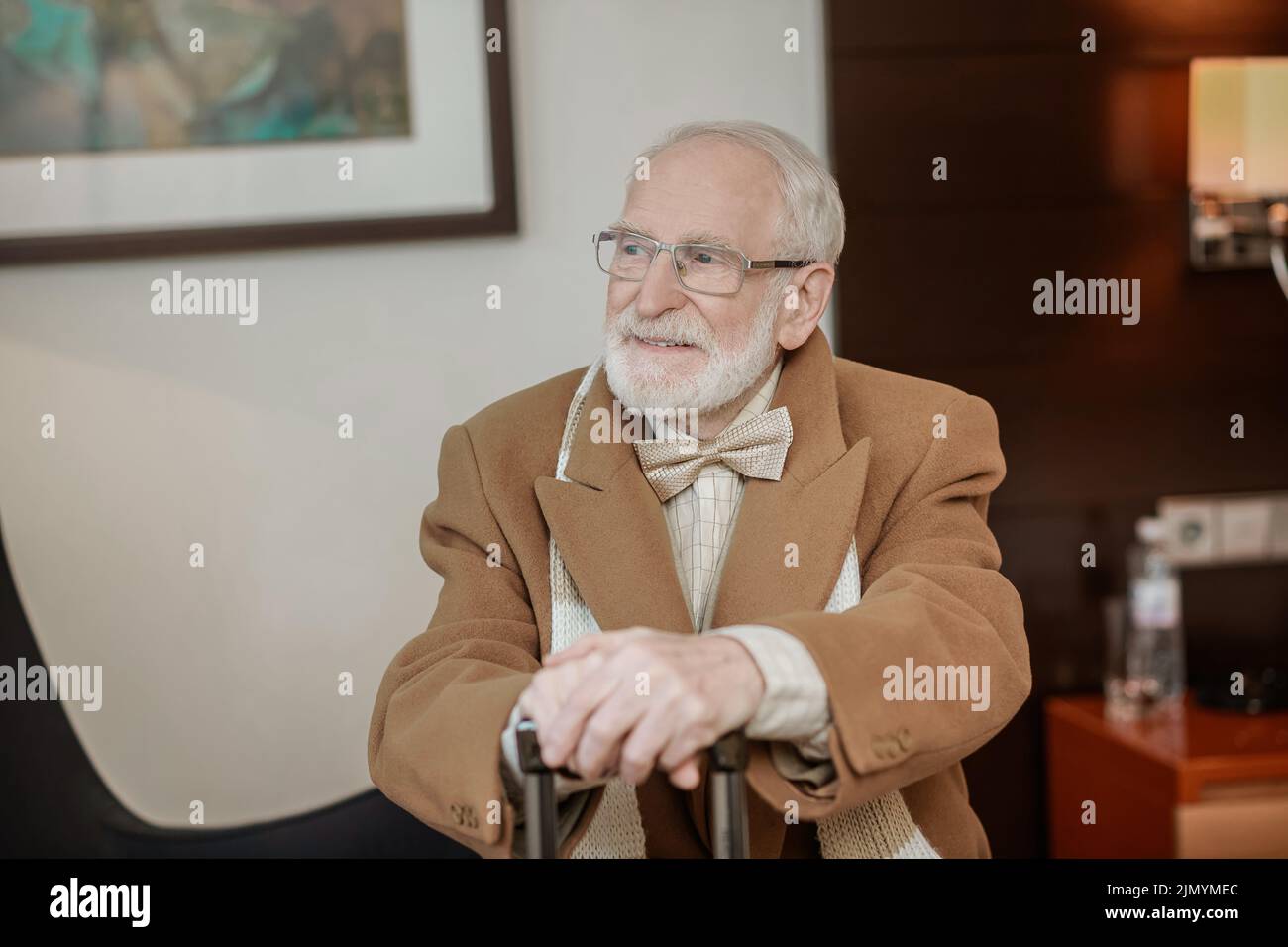 Gentiluomo bearded seduto in una poltrona in un hotel Foto Stock