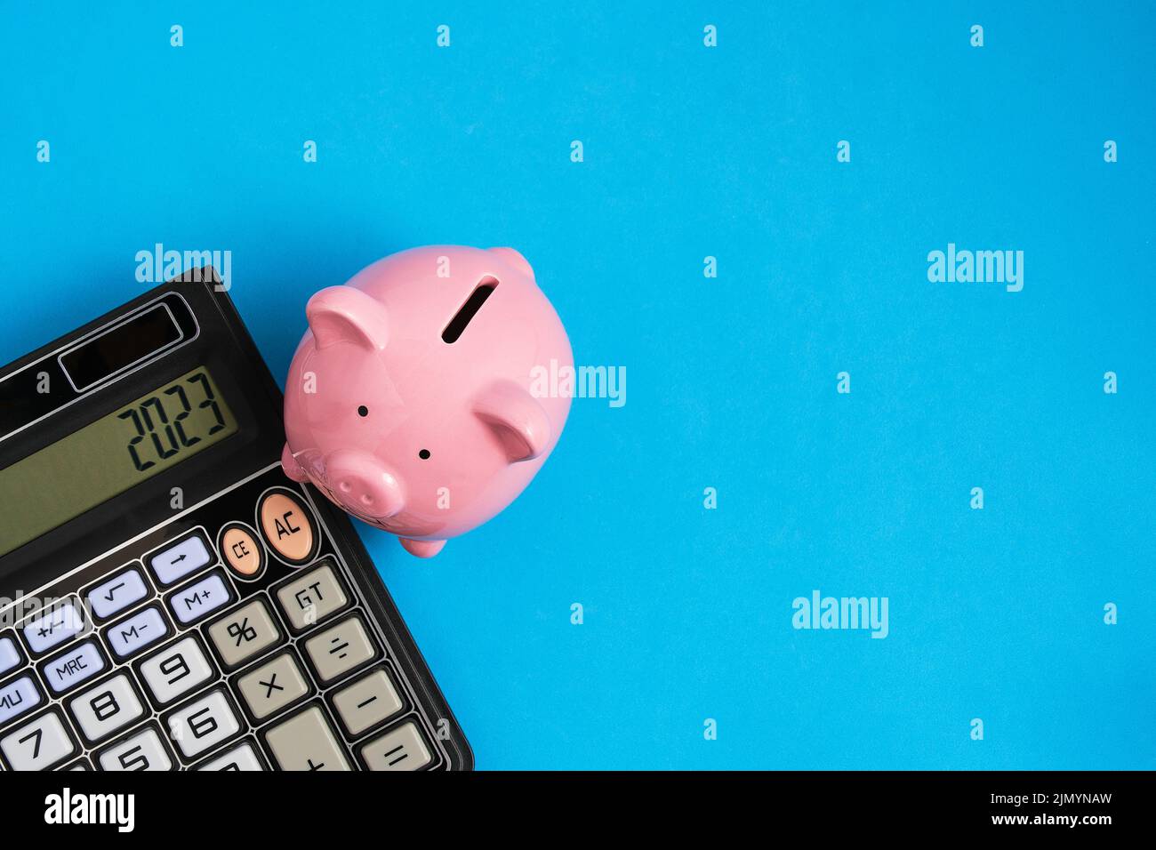 Calcolatrice e Piggy banca blu background.Concept famiglia bilancio e business Foto Stock