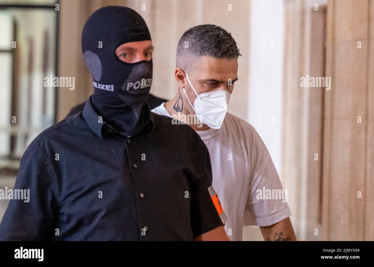 Berlino, Germania. 08th ago 2022. Anis Mohamed Youssef Ferchichi (r), noto con il suo nome di palcoscenico Bushido, entra in un tribunale accompagnato da ufficiali di polizia all'inizio del processo contro la testa di un noto clan di origine araba e tre dei suoi fratelli. Il capo del clan e i suoi fratelli sono in prova per, tra l'altro, aggrava l'estorsione predatoria, privazione della libertà e pericoloso danno corporeo. Credit: Monika Skolimowska/dpa/Alamy Live News Foto Stock