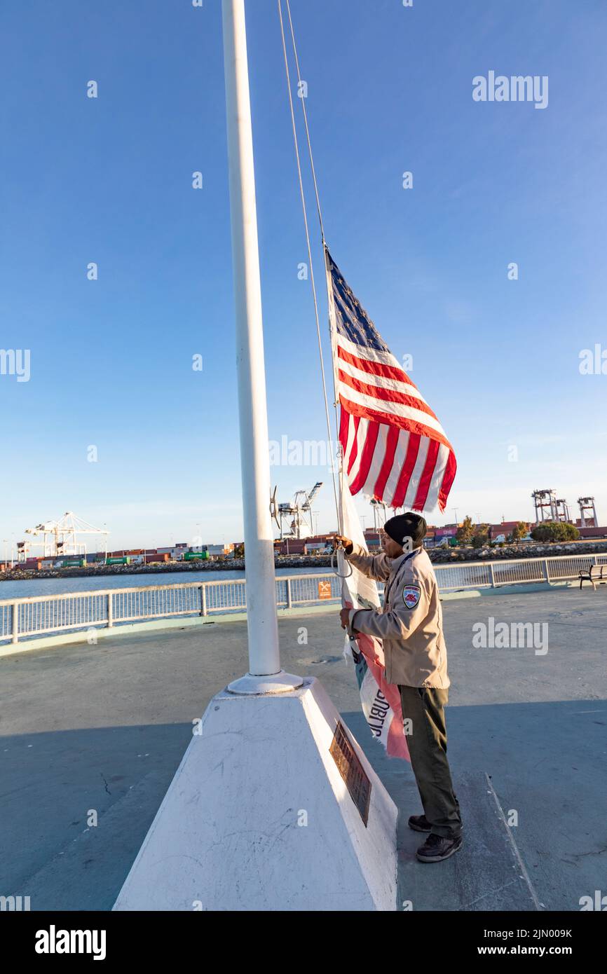 Oakland, USA - 19 maggio 2022: Man alza la bandiera al porto di Oakland. Foto Stock