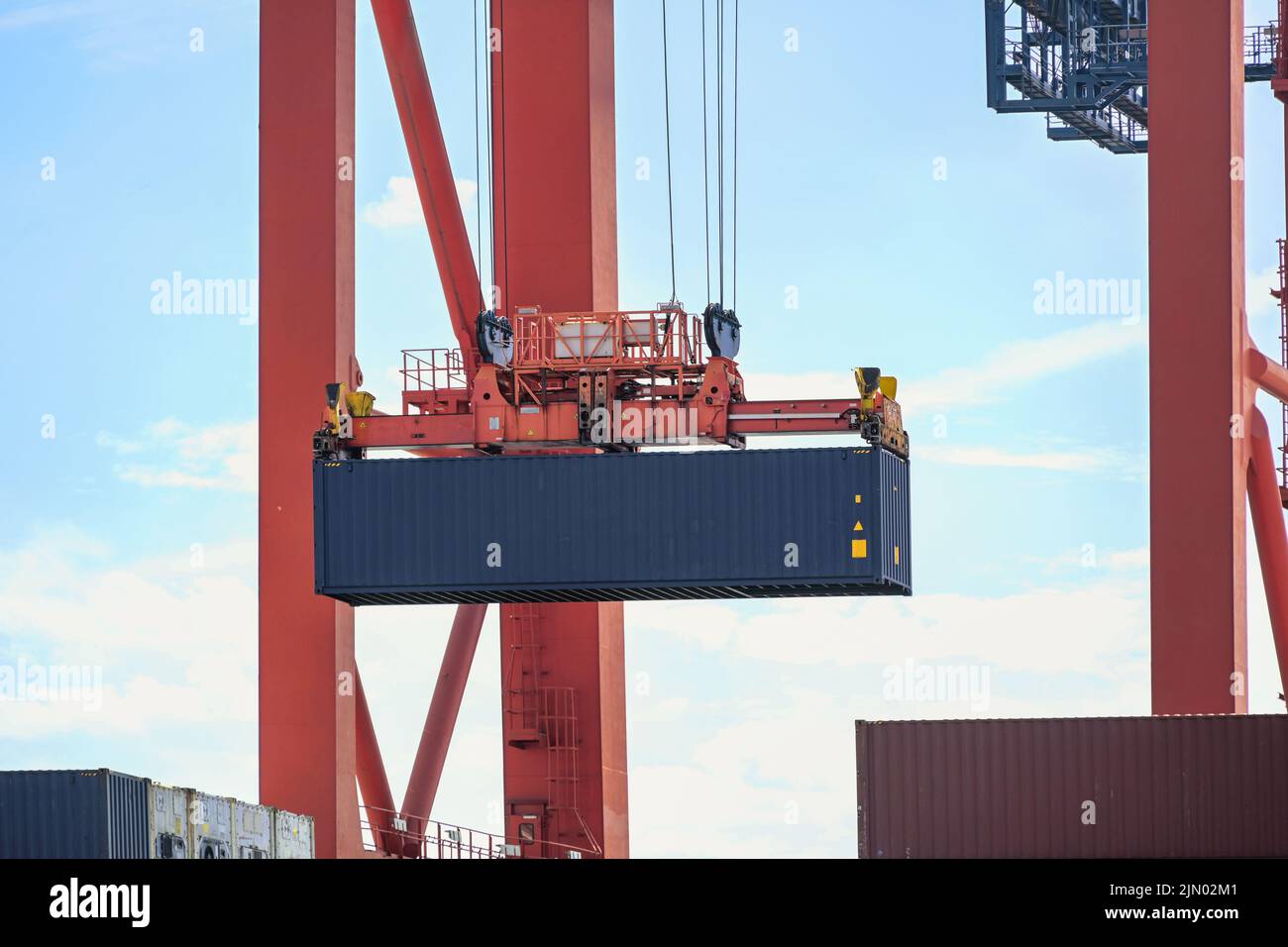 La gru terminale sta spostando un container nel magazzino di carico industriale Hamburgt, concetto per il trasporto, la spedizione e la logistica, spazio coy, fuoco selezionato Foto Stock