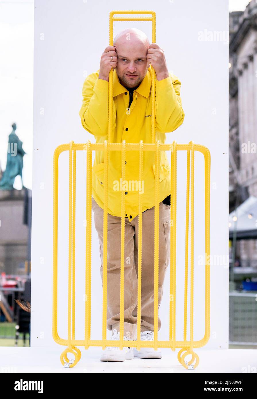 L'artista Kostya Benkovich, fuggito dalla Russia a causa della sua posizione anti-guerra, presenta la sua scultura The Suitcase durante una chiamata fotografica ai Giardini dell'Assemblea, Edimburgo. Data foto: Lunedì 8 agosto 2022. Foto Stock