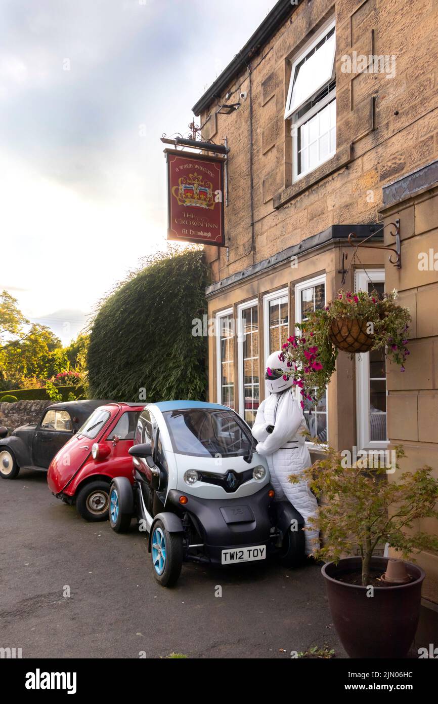 renault twizy e la classica bollicina rossa fuori dal pub Crown nel villaggio di Humshaugh Northumberland Foto Stock