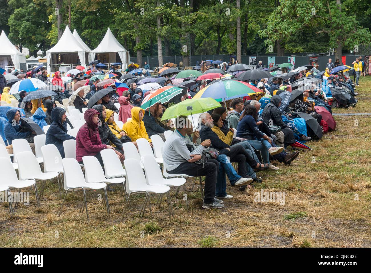 Spettatori che guardano un concerto sotto la pioggia al Django Reinhardt Festival di Fontainebleau, Francia. Foto Stock