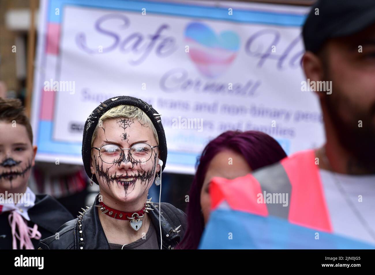 Una giovane ragazza con un volto decorato che partecipa alla vivace e colorata Cornovaglia vanta la sfilata Pride nel centro di Newquay, nel Regno Unito. Foto Stock