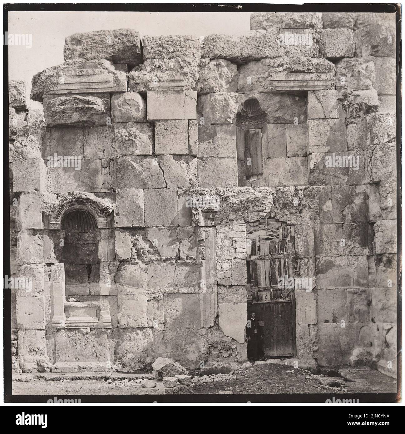 Fotografo sconosciuto, muro con porta, finestra (?) E figure nicchie in Baalbek (senza dat.): Vista (angolo sud del lato est del Großer Hof). Foto, 20,1 x 20 cm (inclusi i bordi di scansione) senza bordi. Fotograff : Wand mit Tür, Fenster (?) Und Figurennische in Baalbek (ohne DAT.) Foto Stock