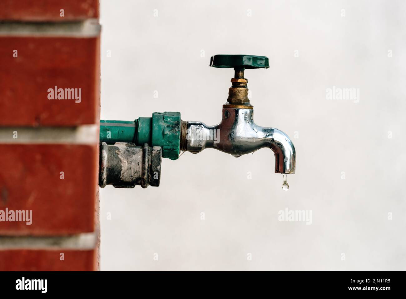 Cortile esterno giardino rubinetto con goccia d'acqua, fuoco selettivo Foto Stock