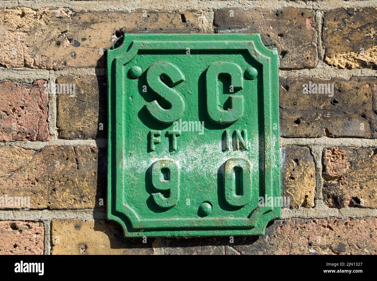 cartello da parete inglese che indica la posizione di un rubinetto, per il controllo dell'acqua di rete, a una distanza di 9 piedi, a brentford, londra, inghilterra Foto Stock