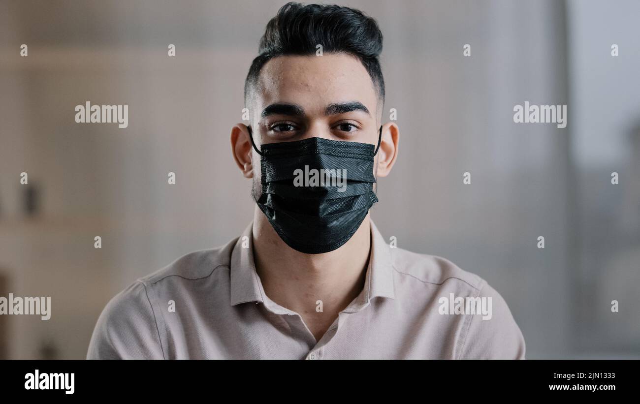 Uomo uomo d'affari maschio arabo ragazzo ispanico indiano capo indossare maschera medica uso protezione respiratore prevenire la diffusione di malattie virali Foto Stock