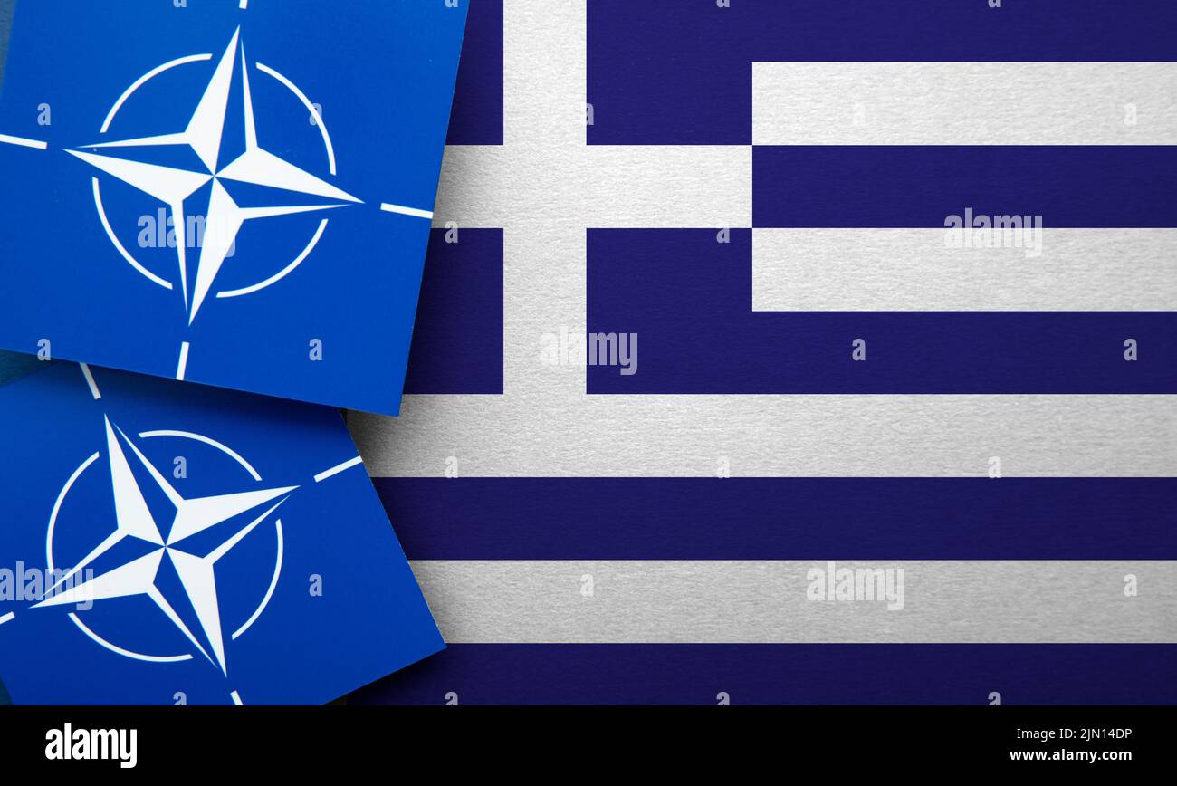 LONDRA, UK - Agosto 2022: Logo dell'alleanza militare della NATO del Trattato Atlantico Nord su una bandiera della Grecia Foto Stock