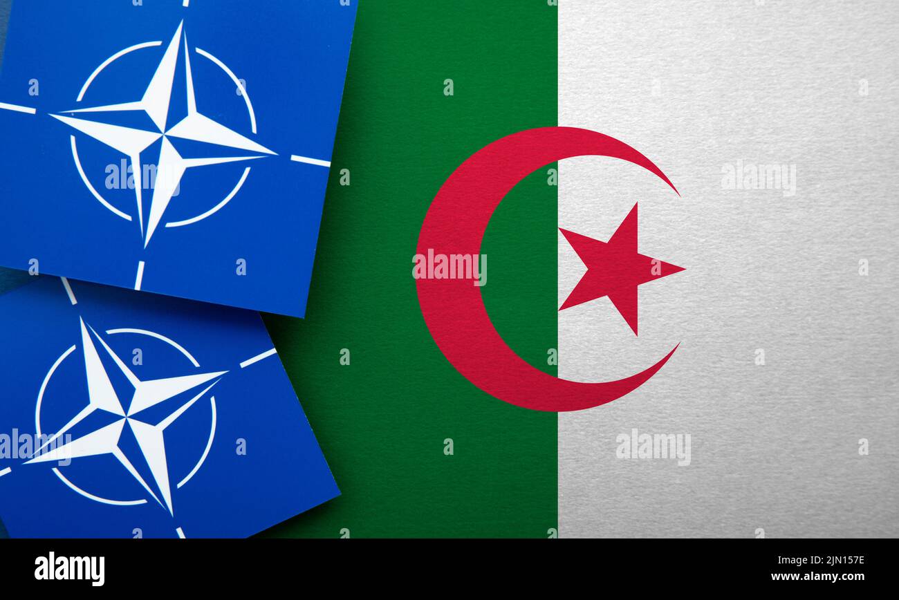 LONDRA, UK - Agosto 2022: Logo dell'alleanza militare della NATO del Trattato Atlantico Nord su una bandiera dell'algeria Foto Stock