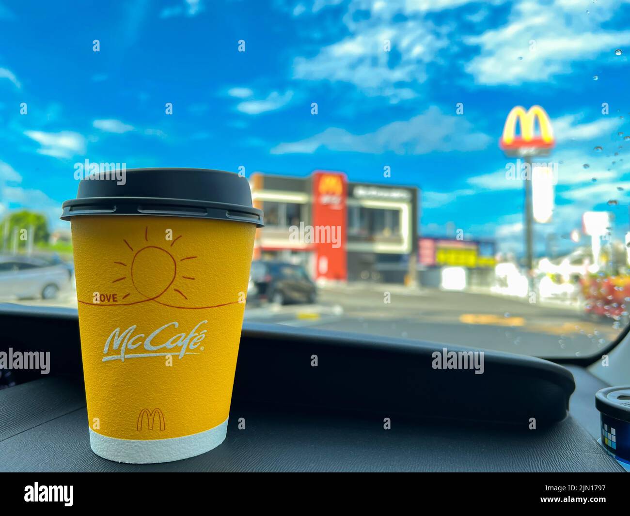 Tazza gialla di caffè McCafe Japan sul cruscotto di un'auto acquistata al servizio drive-thru McDonald's. Foto Stock