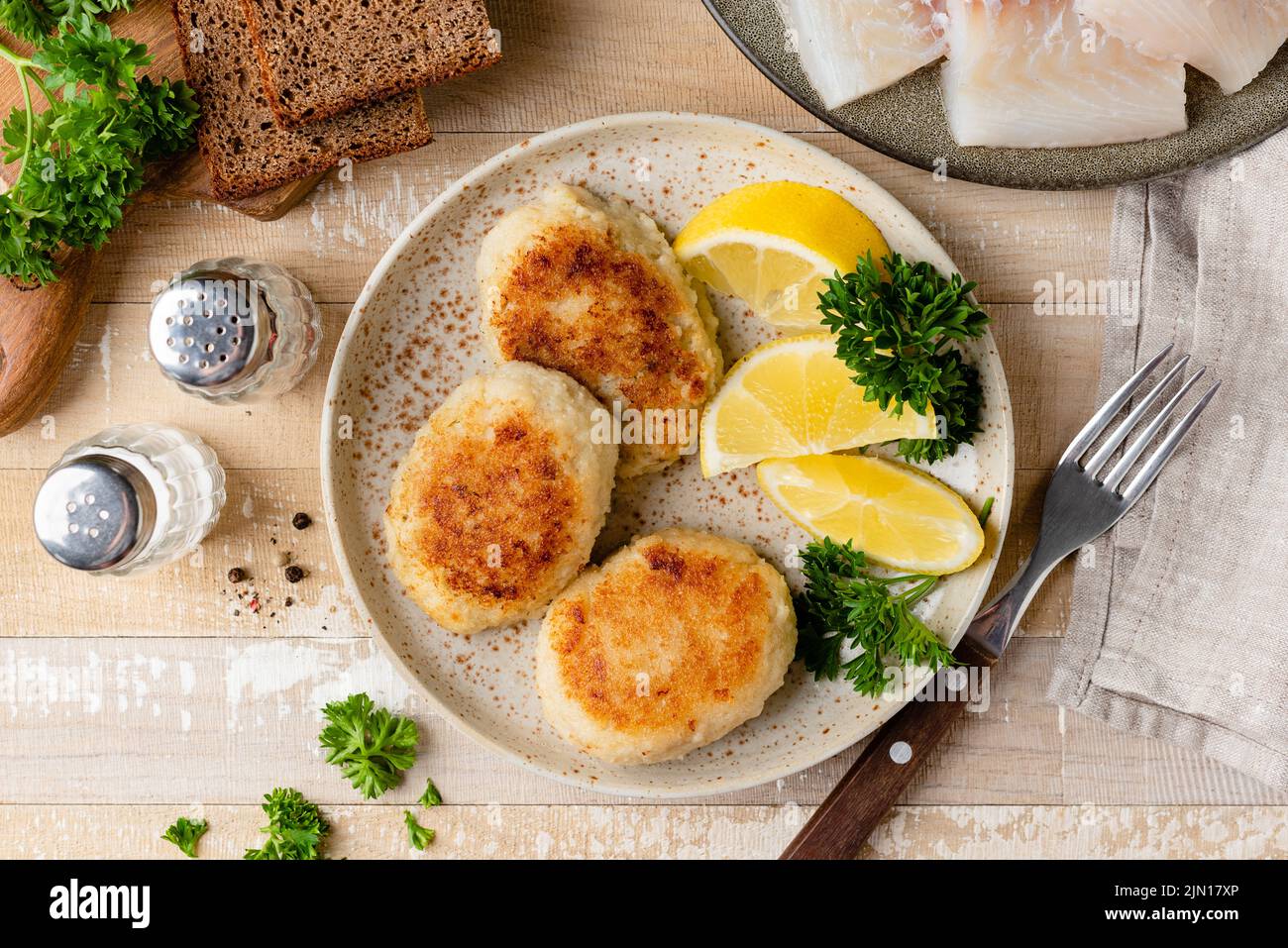 Torte di pesce, polpettine o cotolette su un piatto. Tortino di merluzzo fritto in pangrattato Foto Stock