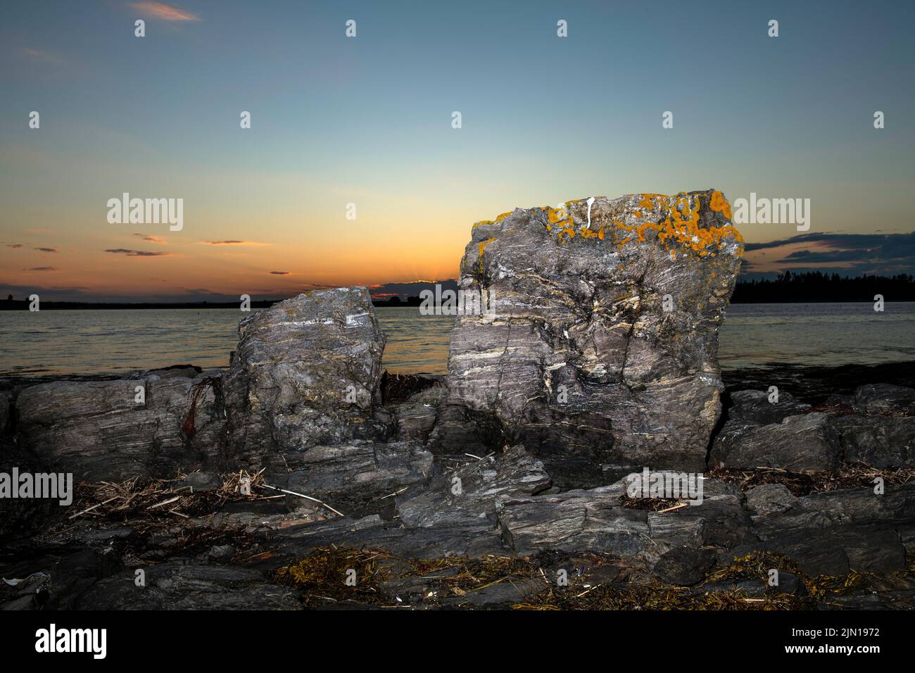 Luglio 6, 2022. 8:16:34 pm. Due rocce al tramonto. Isola di Barnes. Baia di casco, Maine. Foto Stock