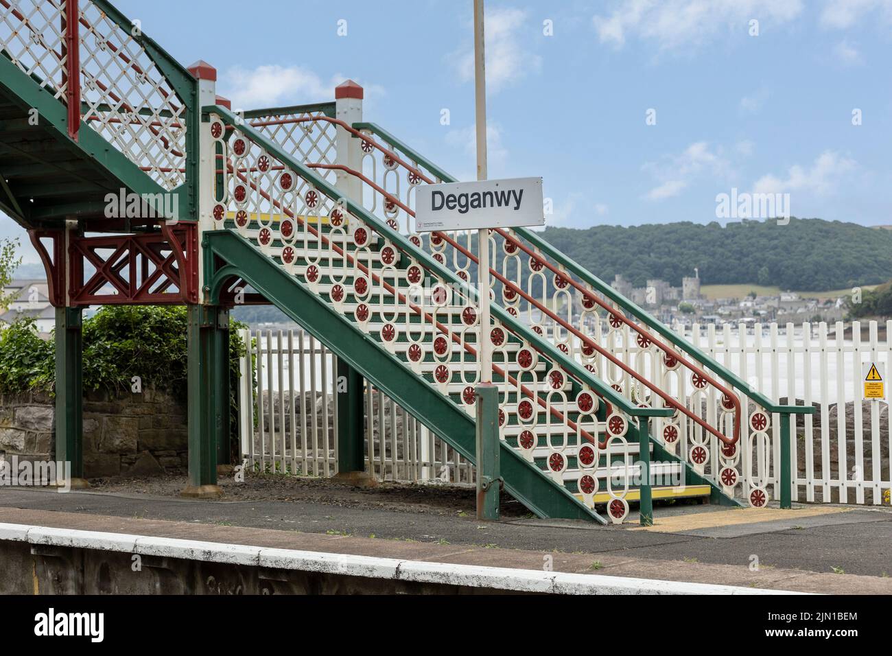 Deganwy North Wales regno unito 01 agosto 2022 Deganwy stazione ferroviaria ornate e colorato ponte, castello di conway in background Foto Stock