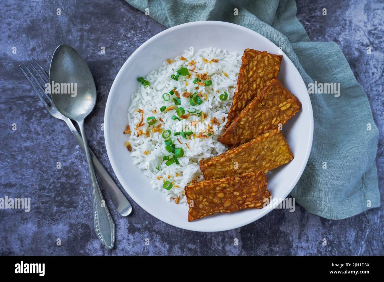 Tempeh fritto con riso in una ciotola, cibo vegetariano Foto Stock