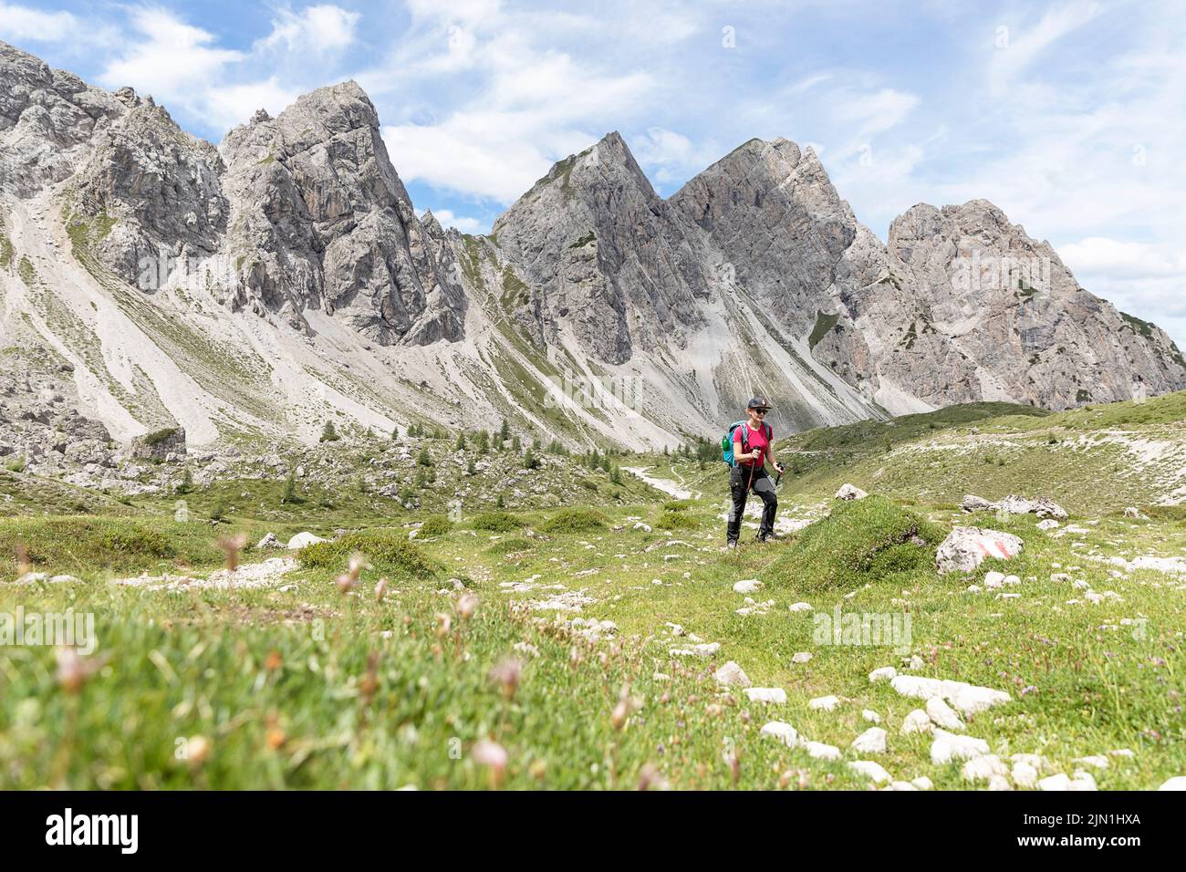 Donna escursionista su un sentiero per Karlsbader Hütte e il lago Laserzsee nelle Dolomiti di Lienz, Tirolo orientale, Austria Foto Stock