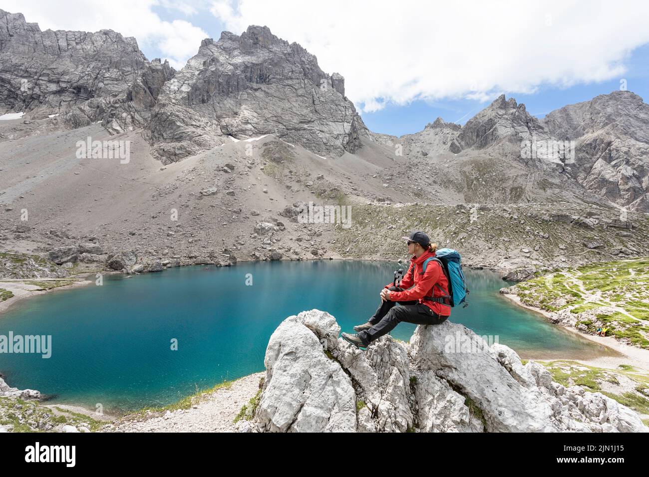 Donna escursionista con un bacPack che guarda il lago alpino Laserzsee, sopra la città di Lienz, nelle Dolomiti di Lienz, Tirolo Orientale, Austria, Europa Foto Stock