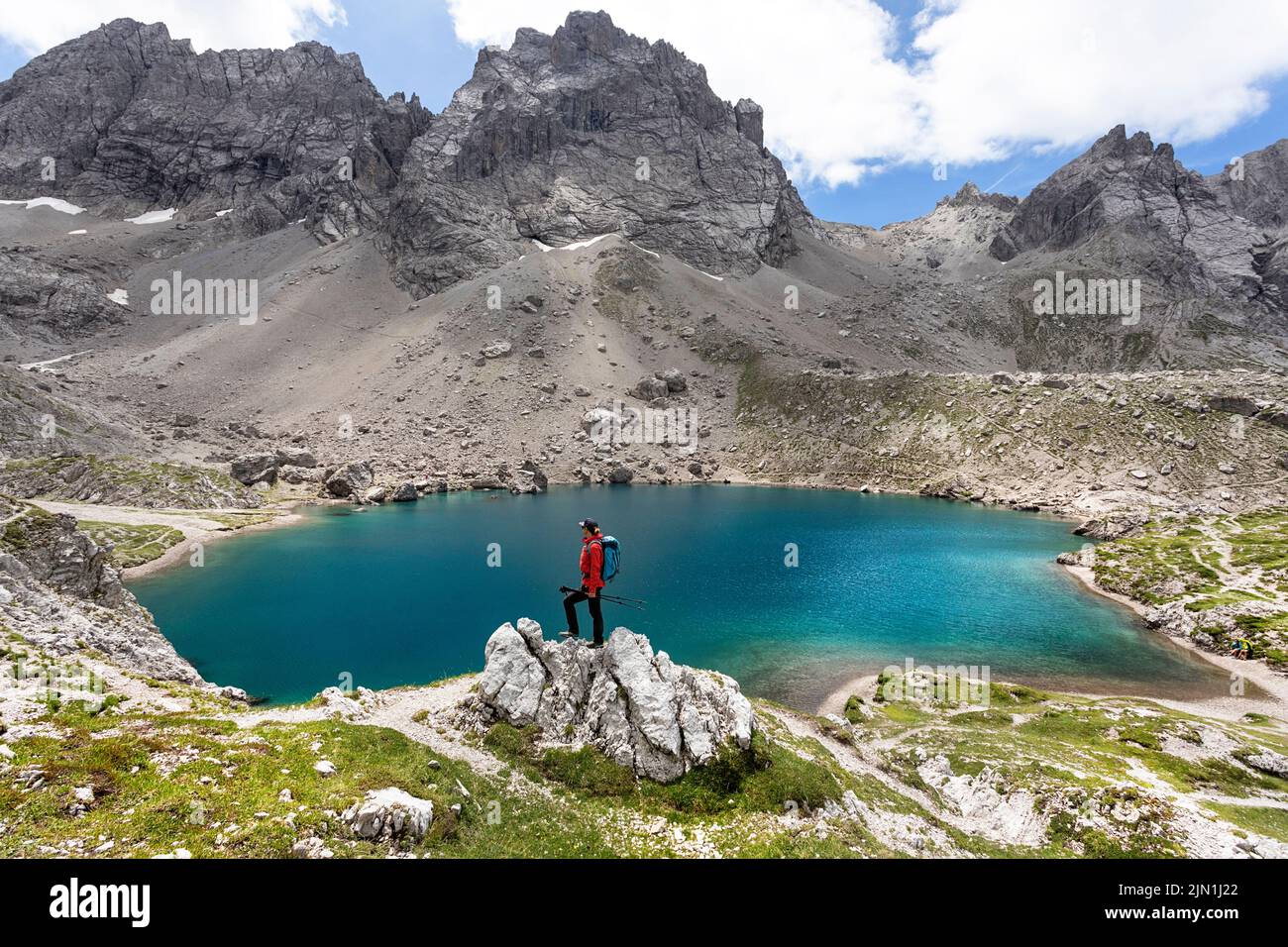 Donna escursionista in piedi su una roccia vicino al bellissimo lago alpino Laserzsee, sopra la città di Lienz nelle Dolomiti di Lienz, Tirolo Orientale, Austria, Europa Foto Stock