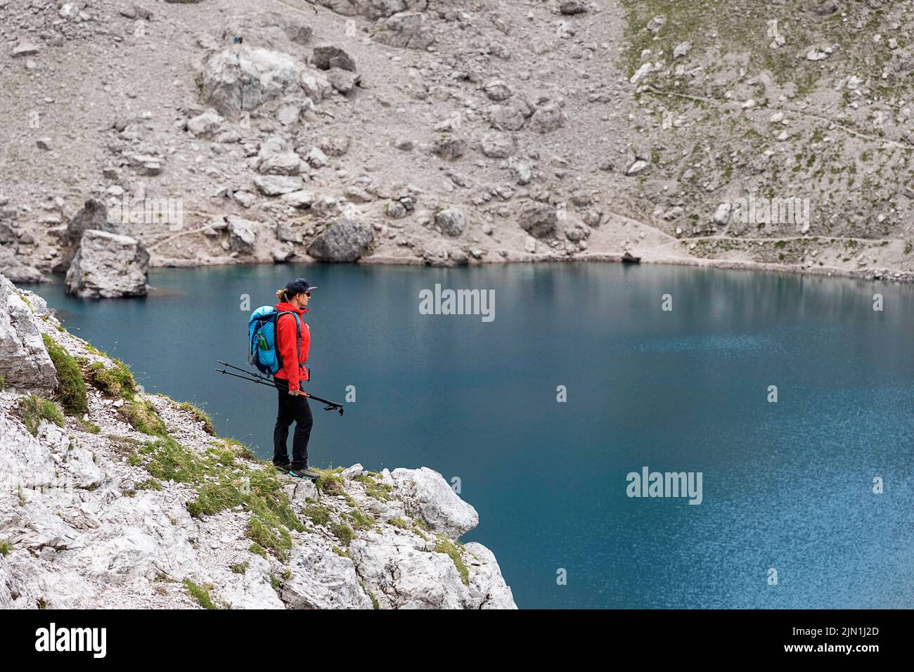 Donna escursionista che guarda il lago alpino Laserzsee, sopra la città di Lienz, nelle Dolomiti di Lienz, Tirolo Orientale, Austria, Europa Foto Stock